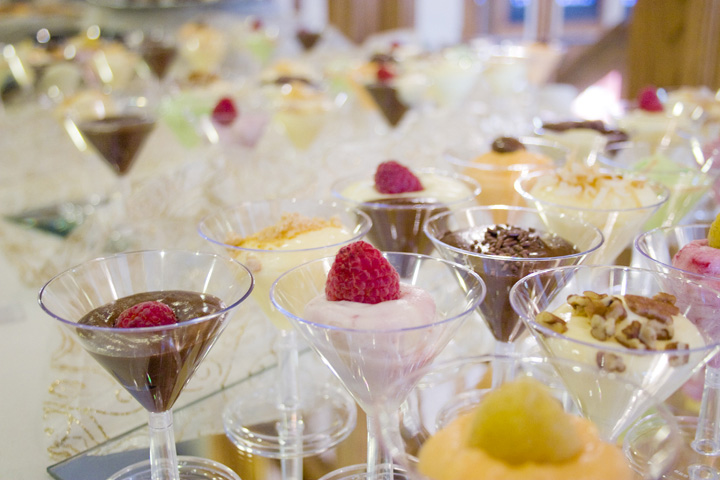 A dessert hors d'oeuvres display with puddings, mousses, cremes and more.